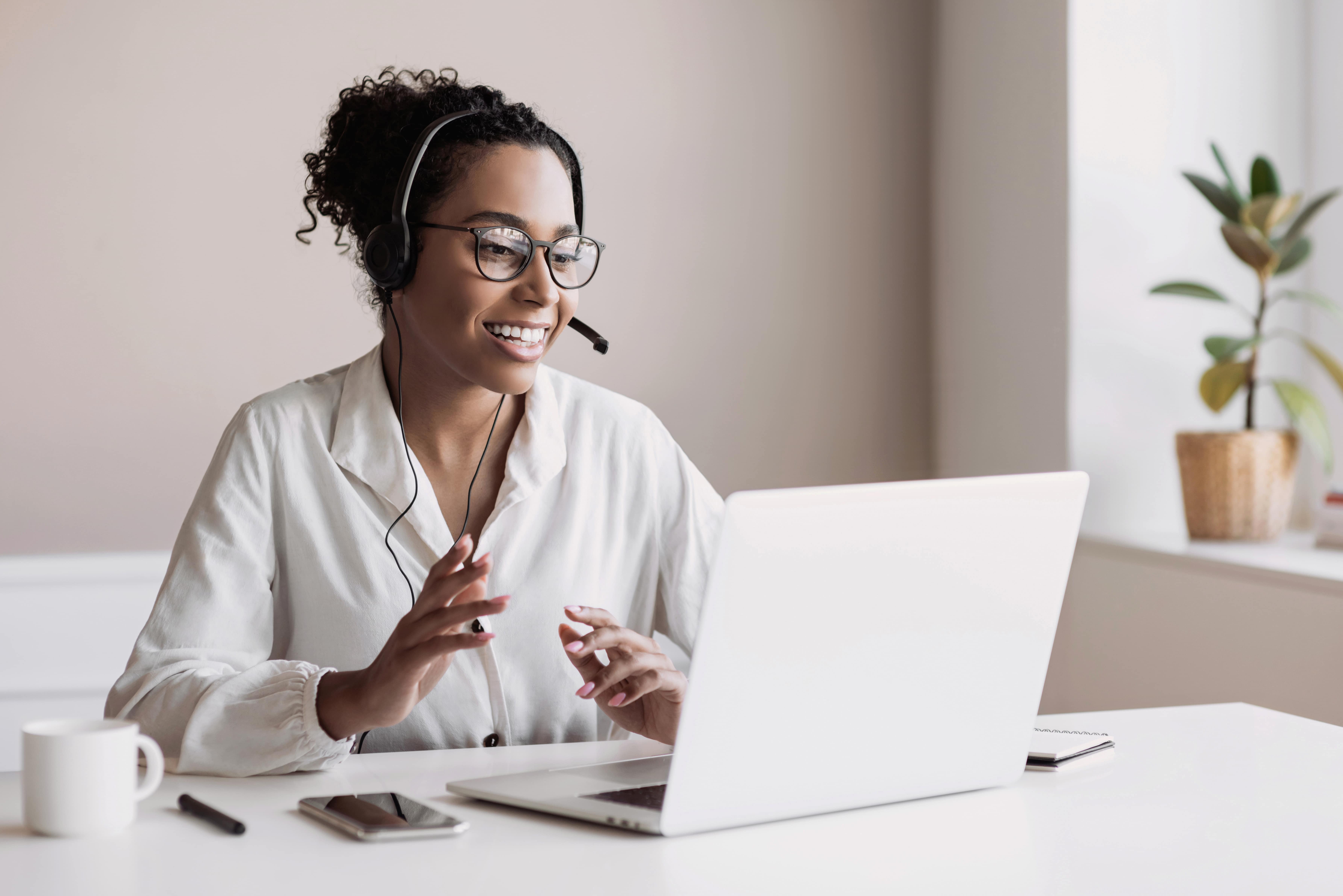 Female customer support specialist smiling while discussing project on computer monitor